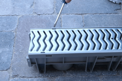 Channel Drain Grate Removal Step 2: Insert flat tool into the slot.